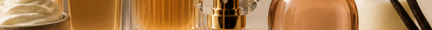 Perfume bottles arranged with vanilla pods and caramel dessert ingredients on a neutral surface