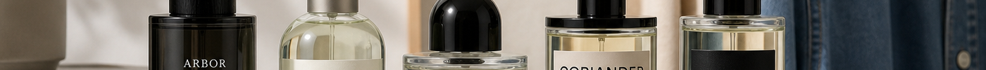 A group of perfume bottles arranged on a minimal shelf with soft daylight and neutral everyday accessories.